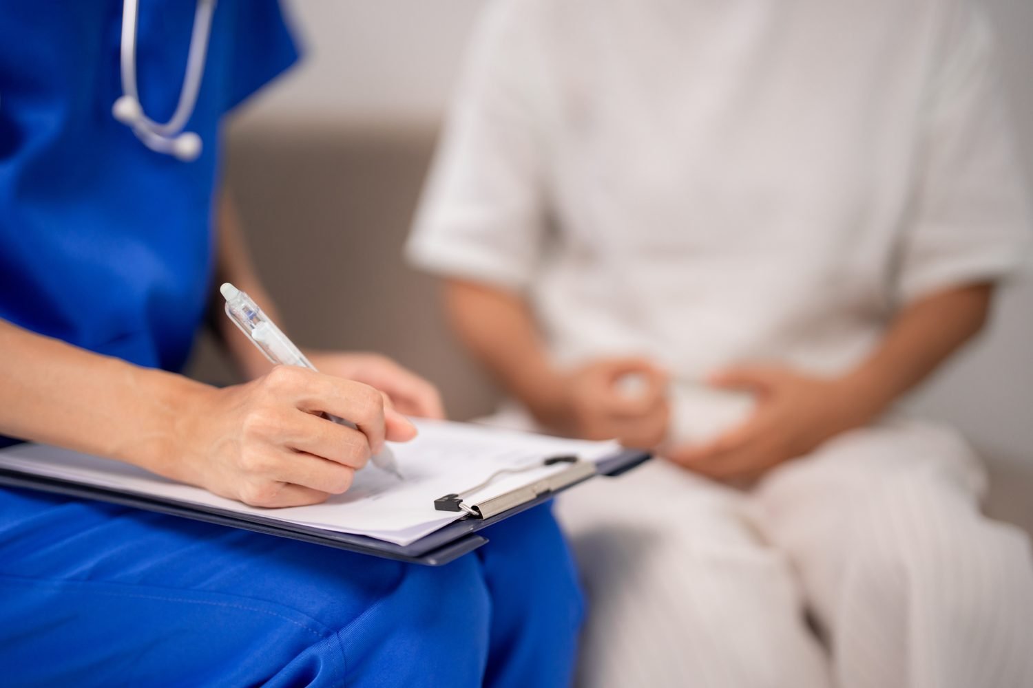 Nurse writing on paper clipboard